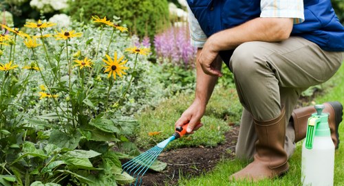 Gardeners sorting green waste into bins next to a suburban home